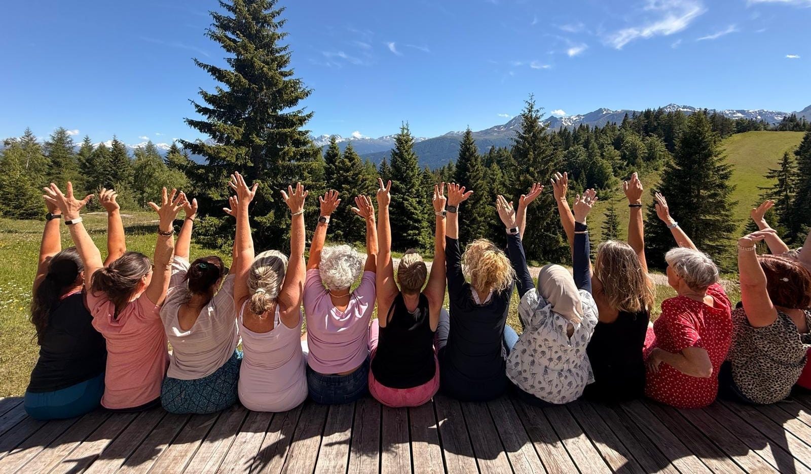 Die Gruppe eines vergangenen FreyMuT Retreats jubelt gemeinsam auf einer Terrasse